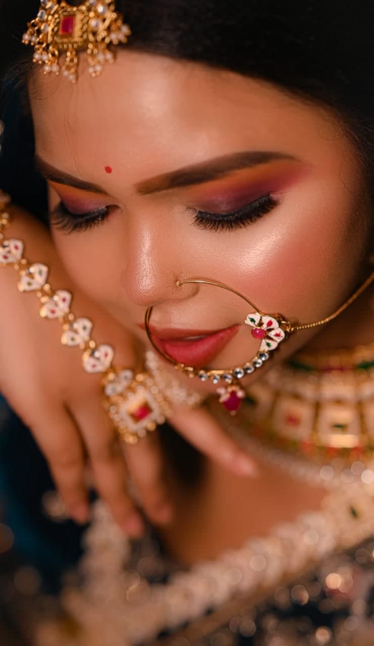 Close study of Sanjana Murmu’s kundan nose ring and layered pearl necklace, eyes lowered.